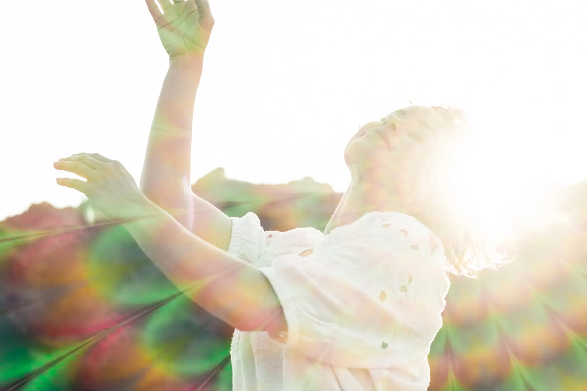 Jaime with her arms raised into bright sunlight