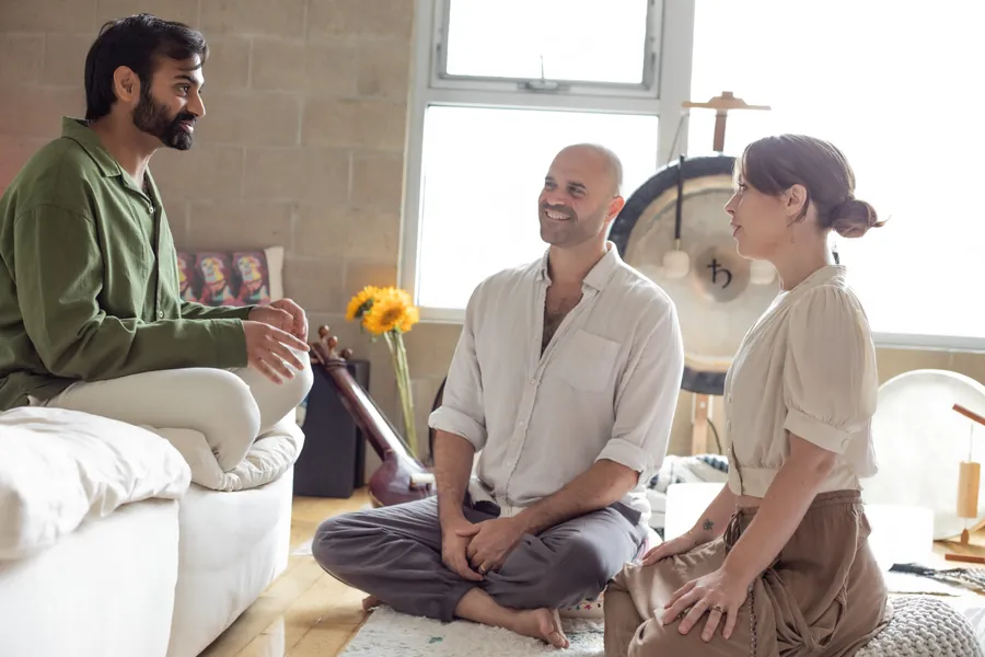 Yonatan laughing with two people seated together during a coaching session at the Word of Mouth studio in Los Angeles