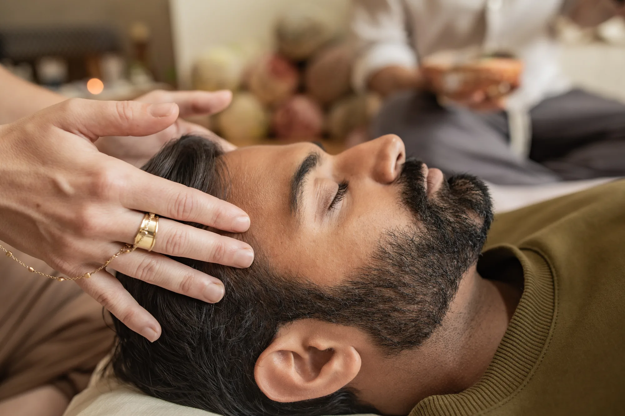 A practitioner's hands resting at a client's head during a reiki session