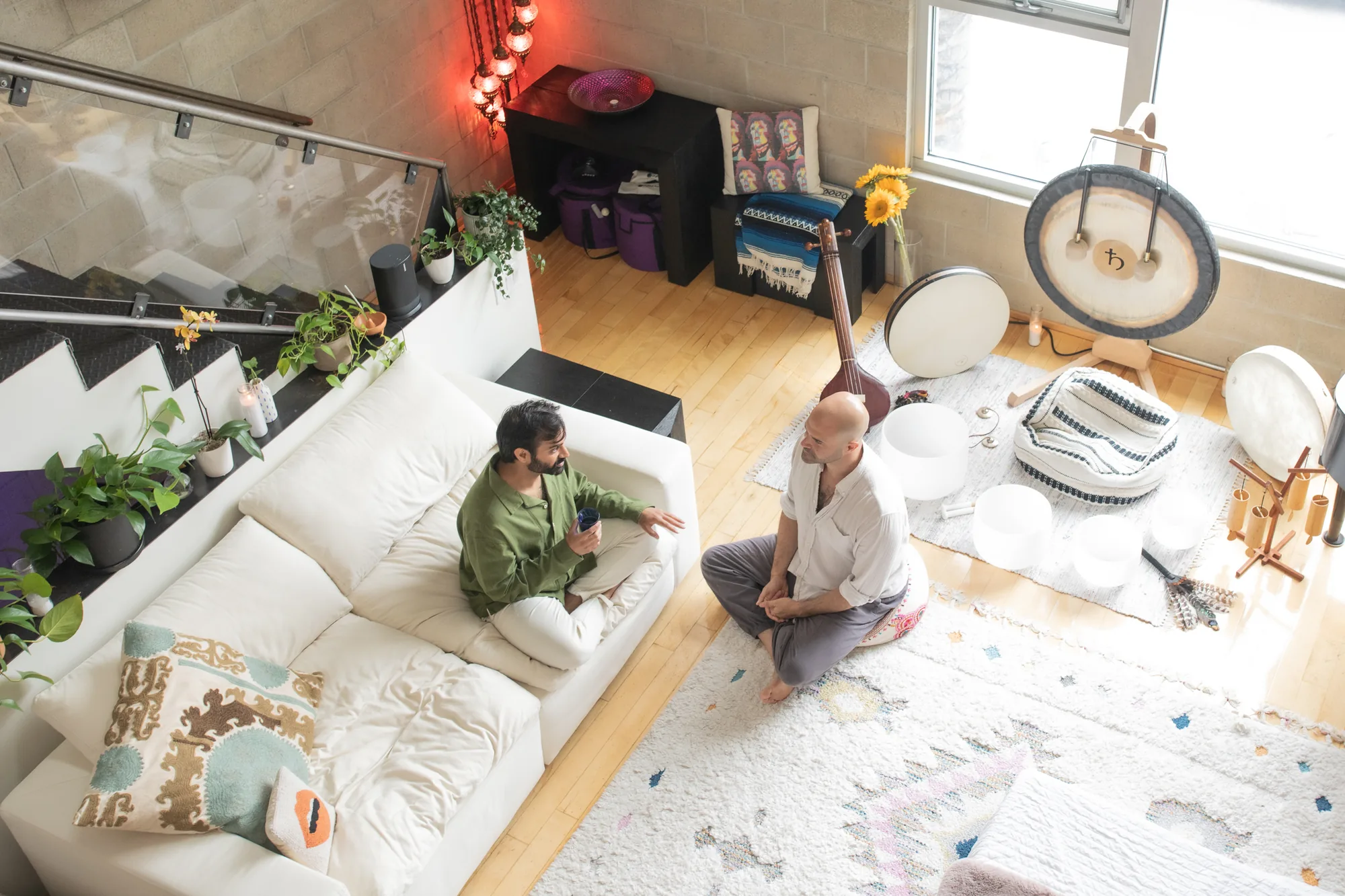 Two people in conversation during a one-on-one coaching session in the Word of Mouth loft studio in Los Angeles, seen from above