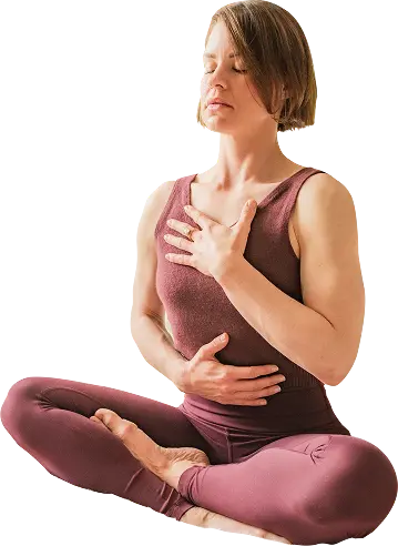 Seated breathwork practice, one hand on chest and one on belly