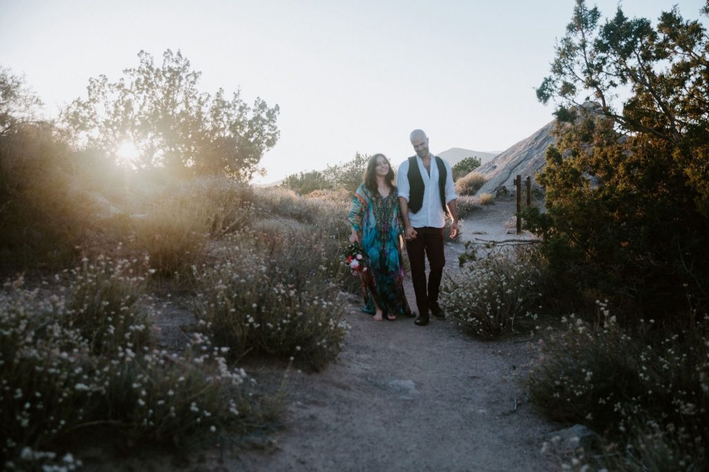 Jaime and Yonatan Elkayam walking a desert trail hand in hand at golden hour