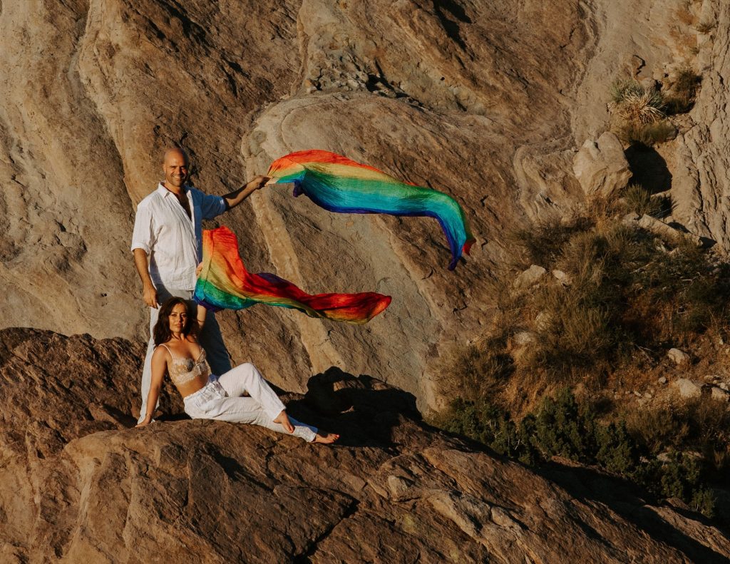 Rainbow silk scarves flying against desert rock