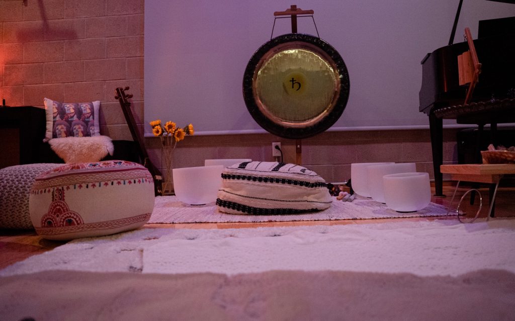 Sound bath setup with gong, crystal bowls and sunflowers at Word of Mouth