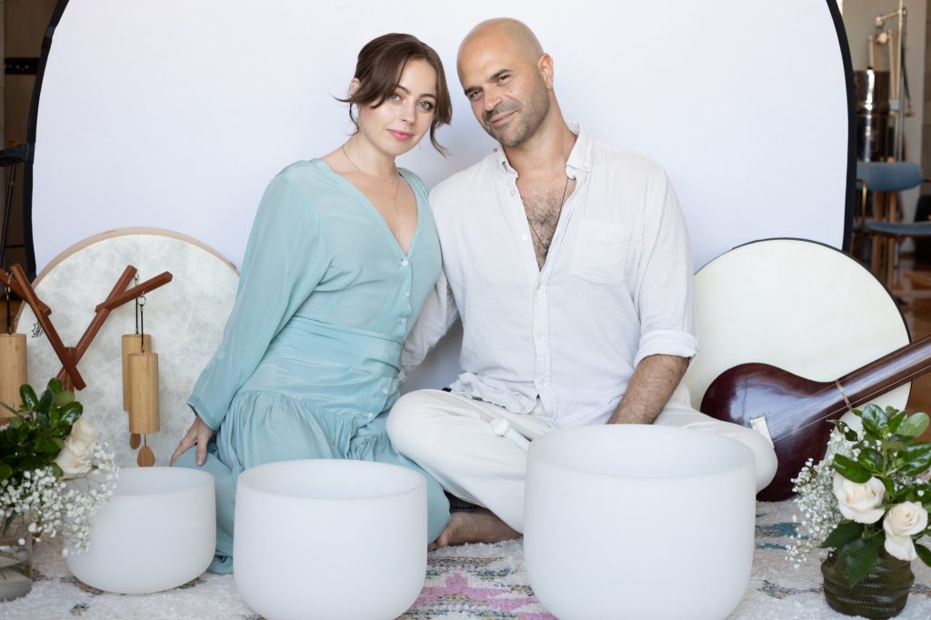 Jaime and Yonatan Elkayam leaning close among their healing instruments