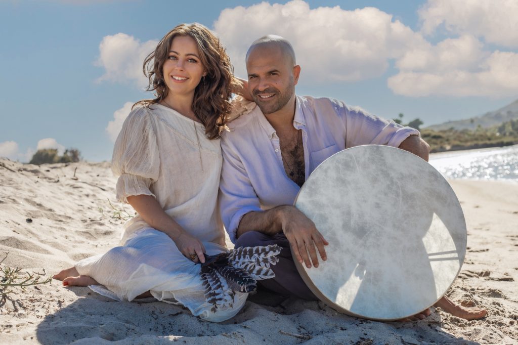 Jaime and Yonatan Elkayam on the beach with a frame drum