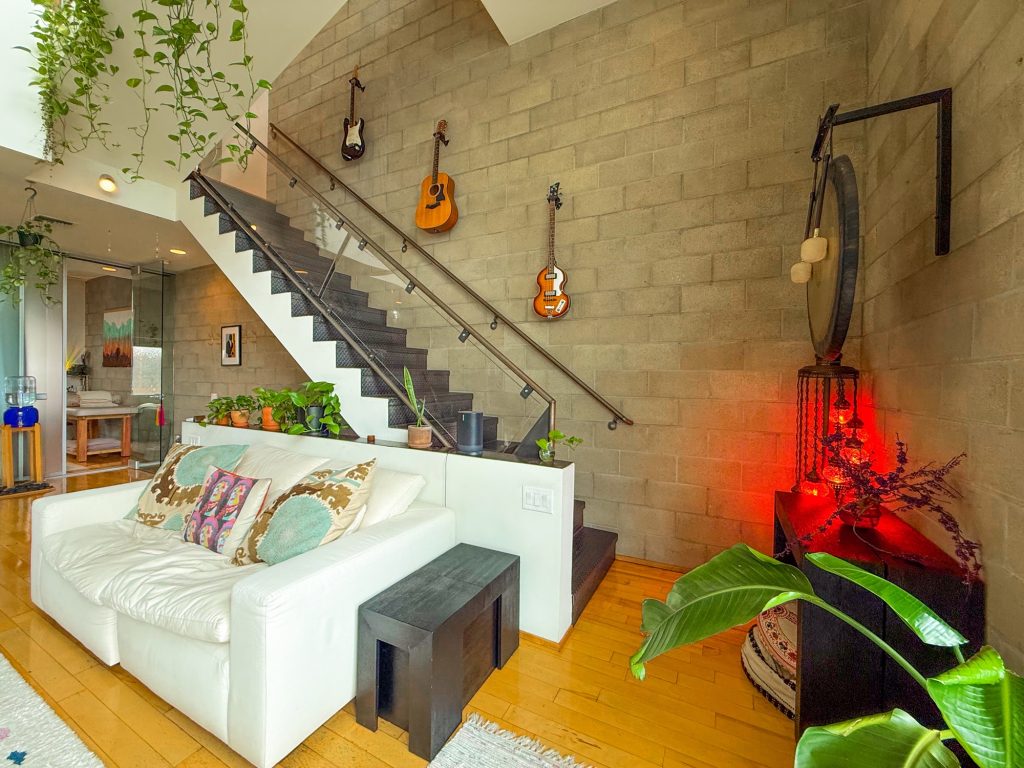 Wide view of the Word of Mouth Sanctuary loft with guitars, gong and white couch